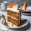 Stück Karottenkuchen mit Creme und Marzipanmöhren-Deko