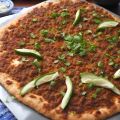 Türkische Lahmacun mit Petersilie und Limettenspalten garniert